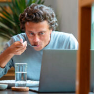 Klau Gago, nutricionista: "Estas son las mejores ideas para organizar bien las comidas entre semana cuando tenemos poco tiempo" hombre comiendo en el trabajo delante del ordenador