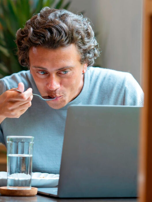 hombre comiendo en el trabajo delante del ordenador