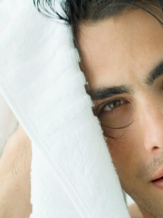 hombre joven secándose el pelo con una toalla de la ducha
