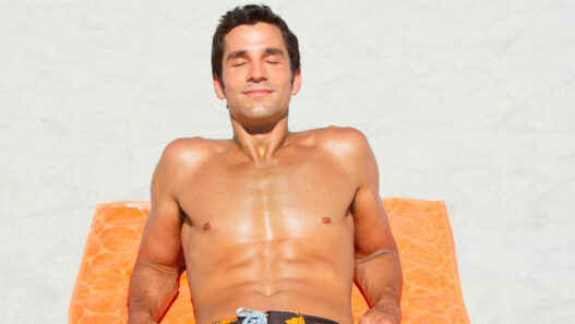 hombre tomando el sol en la playa