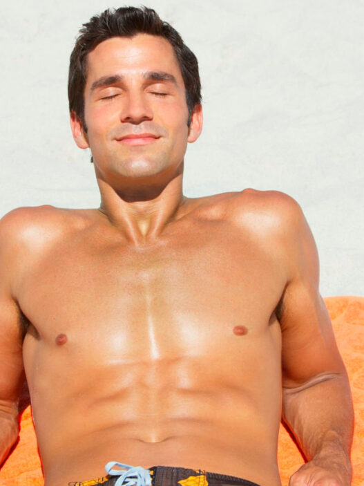 hombre tomando el sol en la playa