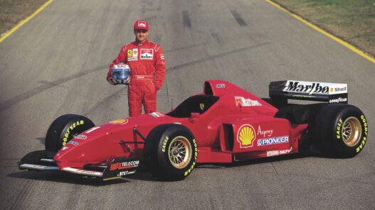 Nicola Larini posando junto al Ferrari F310