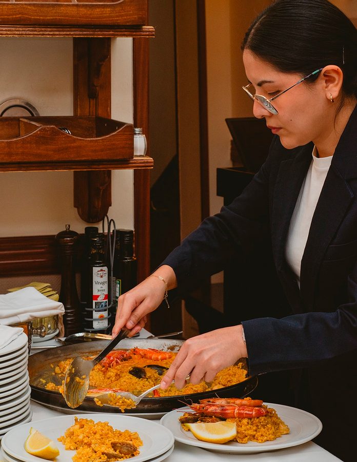 mujer sirviendo arroz en La Barraca (Chueca)