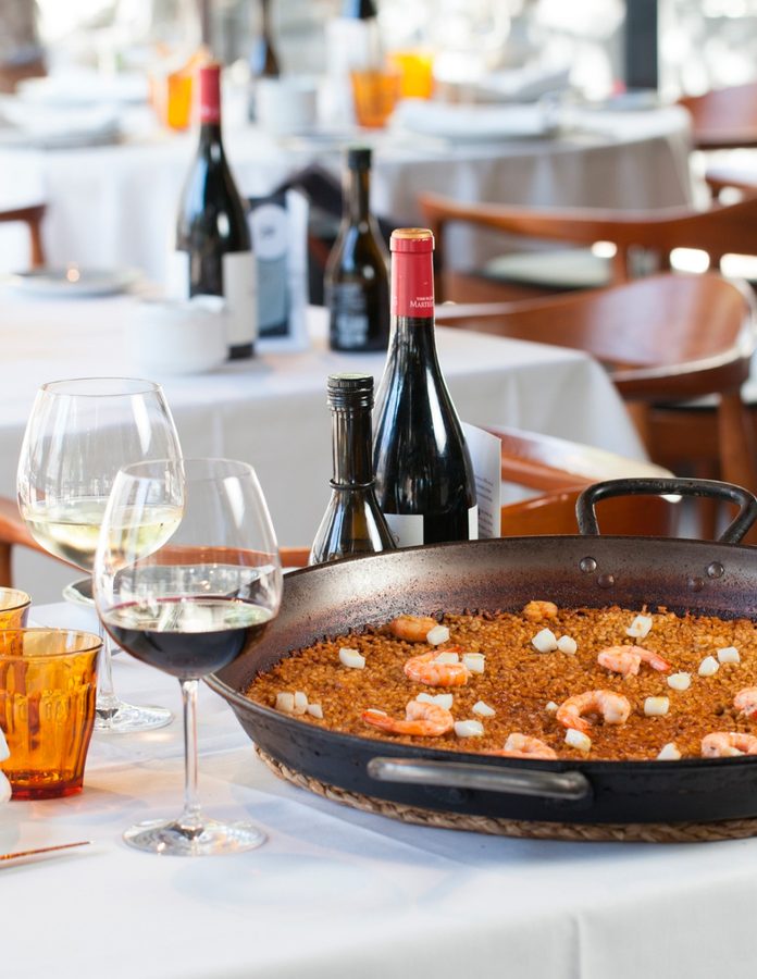 Mesa del restaurante Rocacho de Padre Damian con una paella encima de la mesa