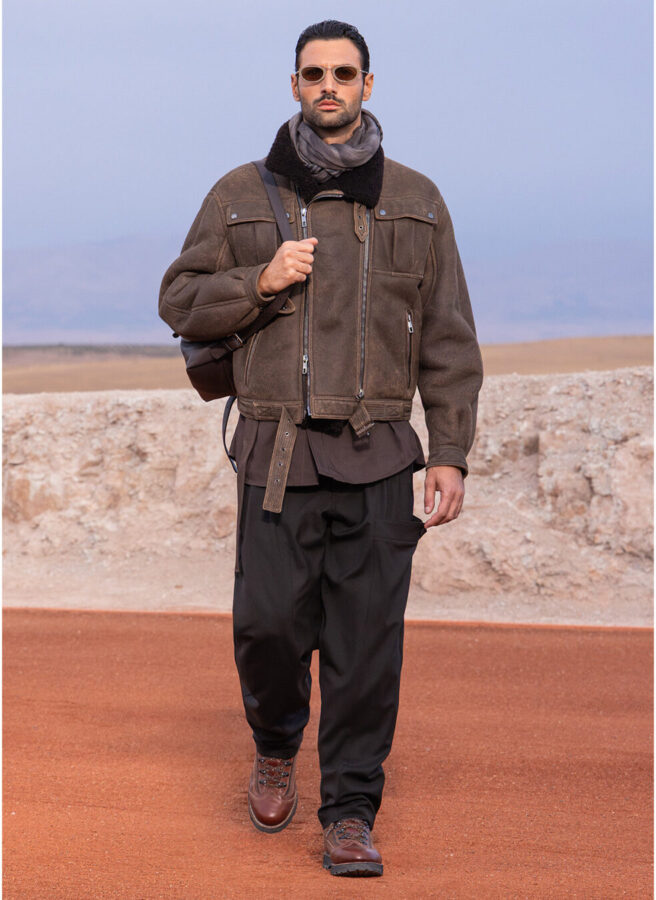 Modelo con chaqueta aviadora de ante marrón con cuello de borrego y pantalón negro de Giorgio Armani & Kith