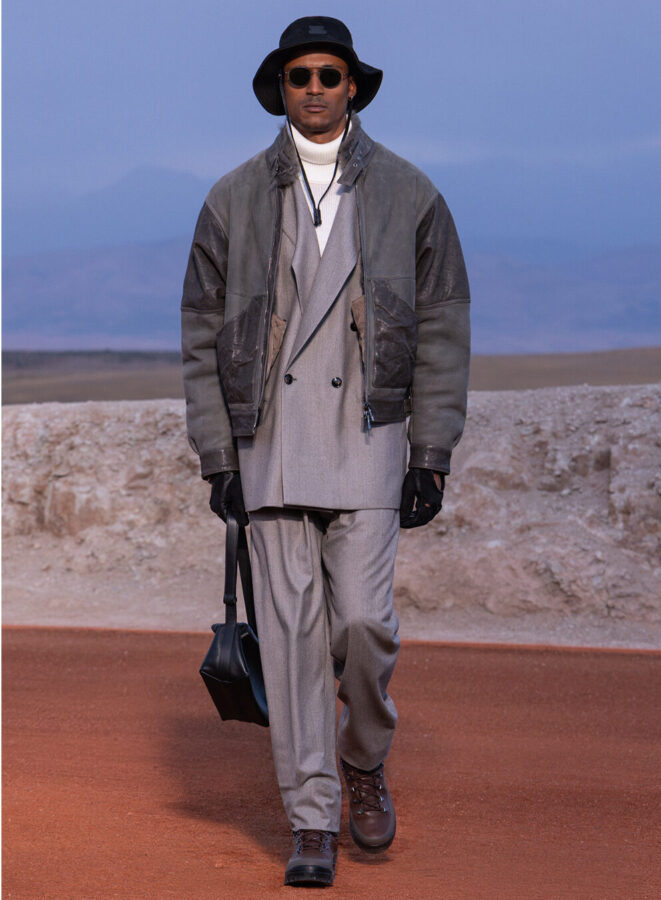 Modelo con chaqueta cruzada de espiga, pantalón cargo a juego y gorra de los Yankees de Giorgio Armani & Kith