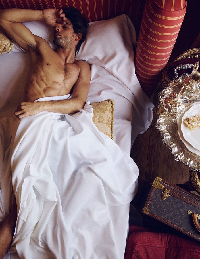 Marlon Teixeira en una cama con baúl de Louis Vuitton sesión de fotos Rísbel Magazine otoño 2026
