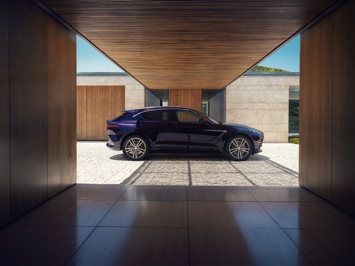 Aston Martin DBX GT de perfil aparcado bajo un porche de madera