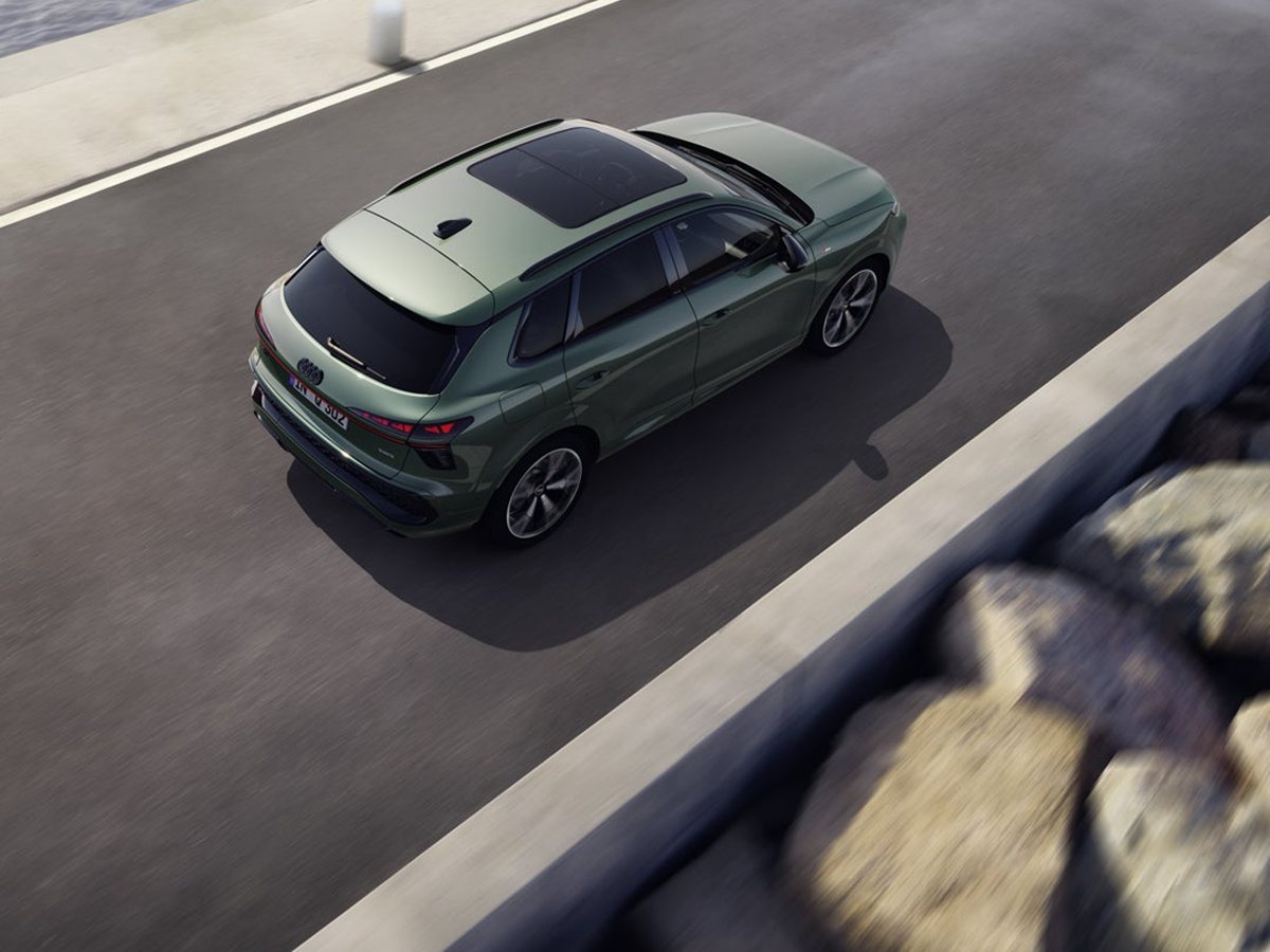 Audi Q3 verde visto desde arriba circulando junto a un paseo marítimo