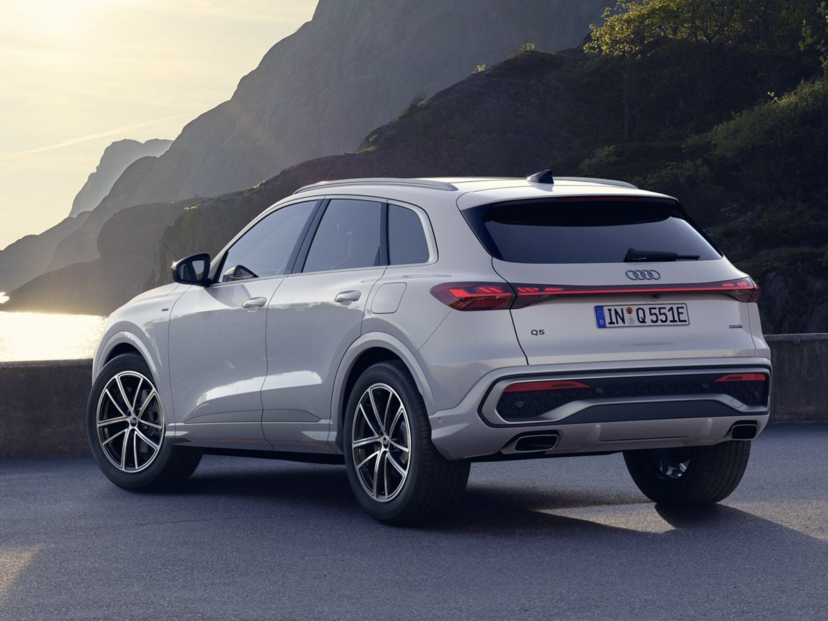 Audi Q5 SUV e-hybrid de tres cuartos delantero circulando por una carretera con vegetación