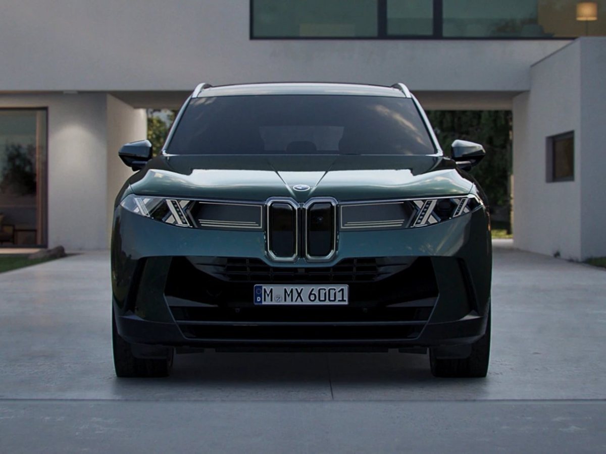 Nuevo BMW X5 verde oscuro de frente aparcado ante una casa moderna