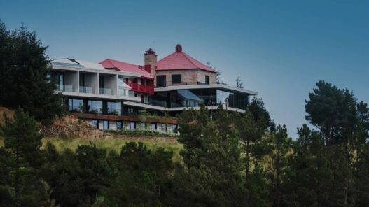 Casa de São Lourenço, hotel de la Serra da Estrela con la antigua pousada de tejado rojo y el cuerpo nuevo de hormigón y cristal entre pinos