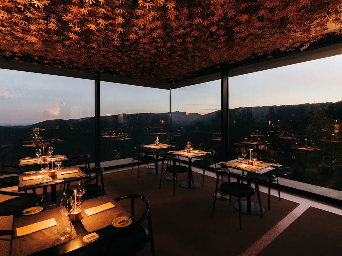 Comedor del restaurante Fatiga de Casa de São Lourenço con techo de flores de burel y cristaleras sobre la Serra da Estrela al atardecer