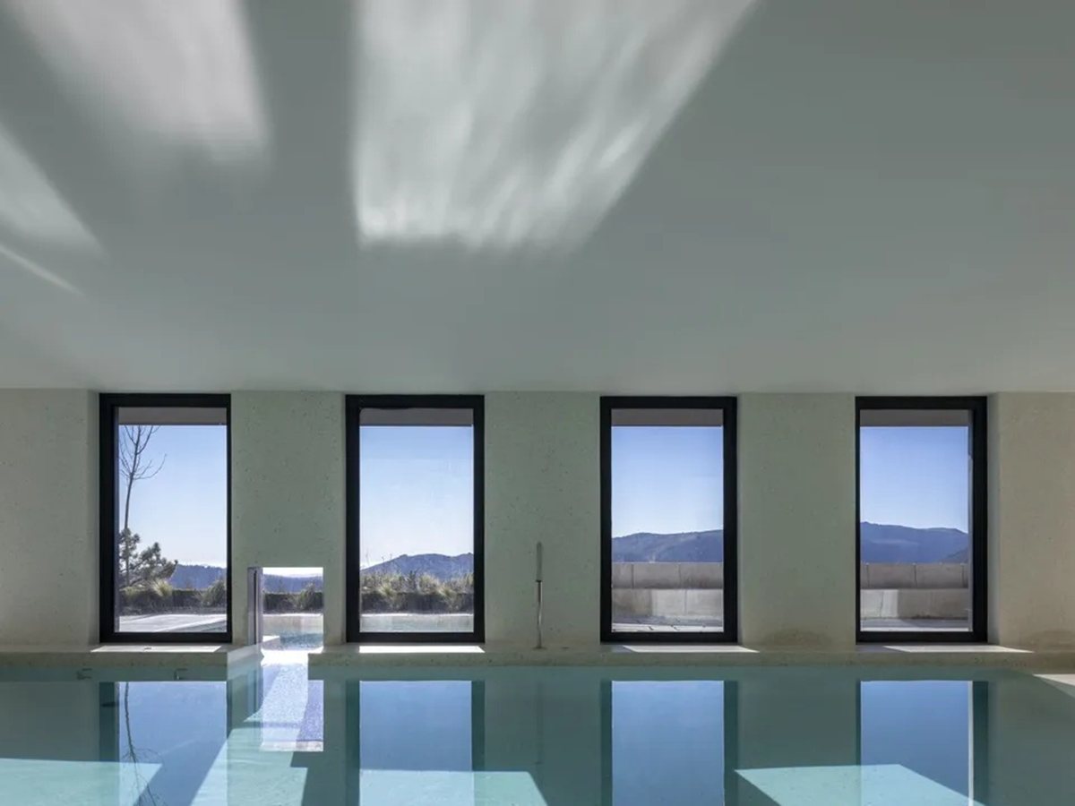 Piscina interior climatizada del spa de Casa de São Lourenço con 6 ventanales a la montaña