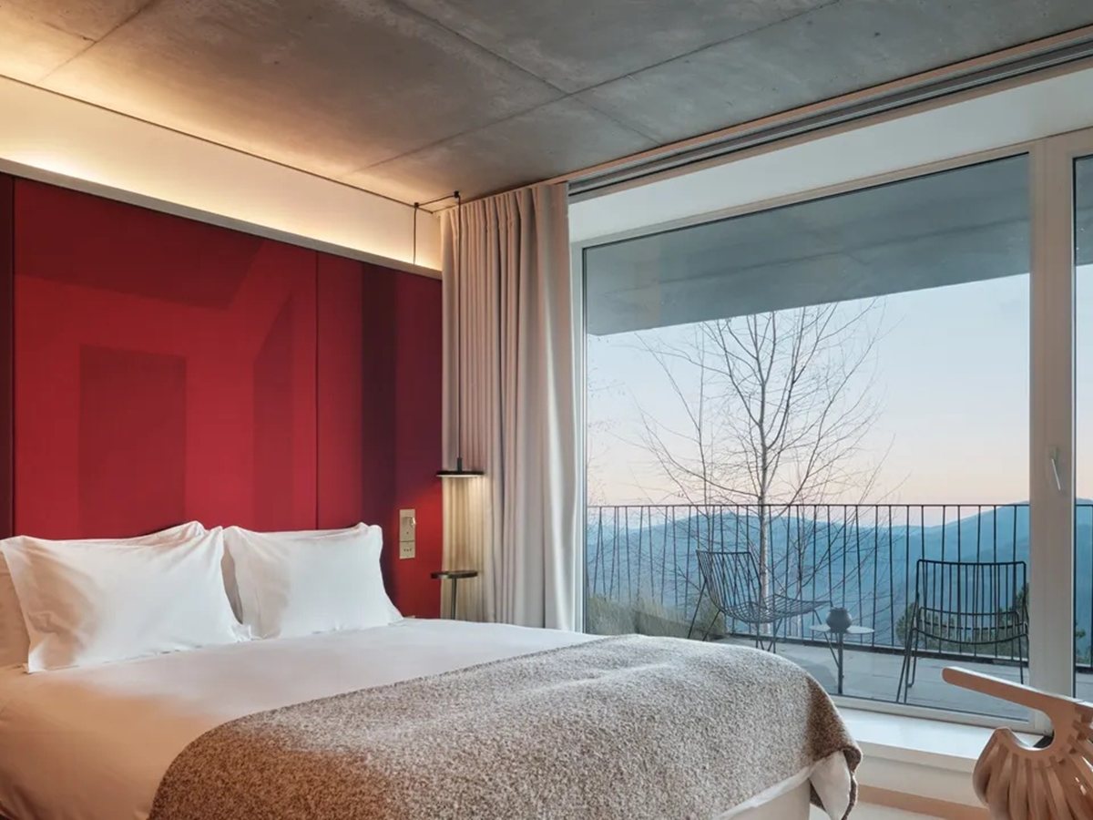 Suite Panorama Plus de Casa de São Lourenço con cabecero rojo, techo de hormigón y balcón sobre el valle glaciar del Zêzere
