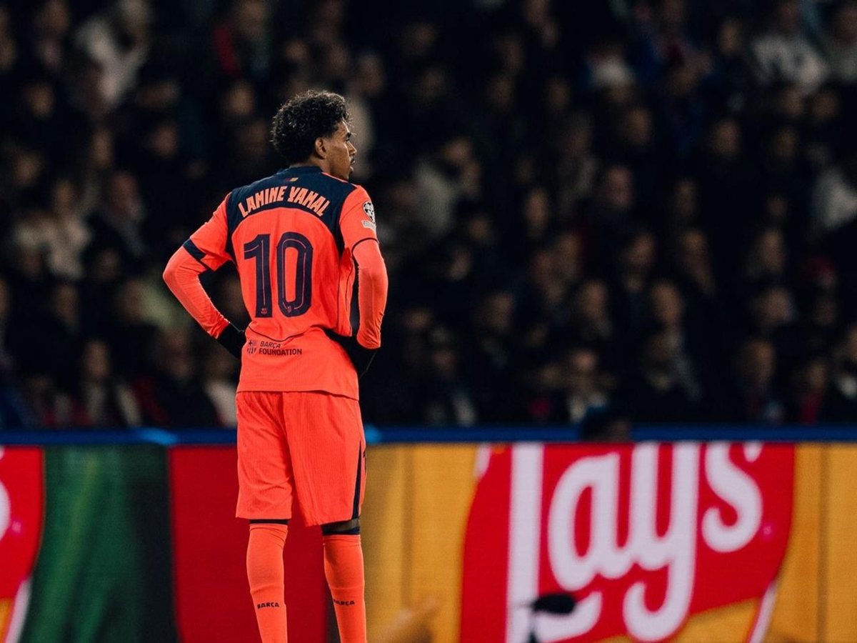 Lamine Yamal de espaldas con la camiseta naranja del FC Barcelona en el Parque de los Príncipes