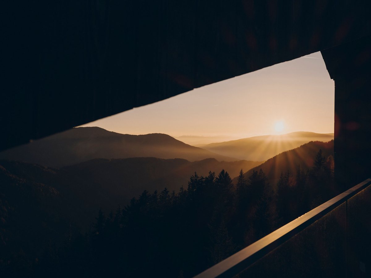 Atardecer sobre los valles del Tirol del Sur visto desde una terraza de madera de FORESTIS