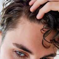 Como experto en belleza, estos son los suplementos para el cabello que me han funcionado para la caída estacional hombre joven mirándose la entrada del cabello