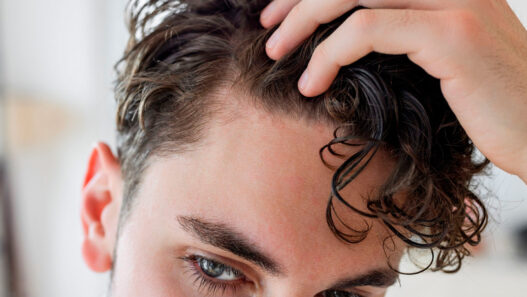 hombre joven mirándose la entrada del cabello