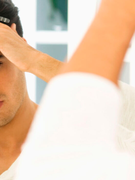 hombre peinándose mirándose al espejo