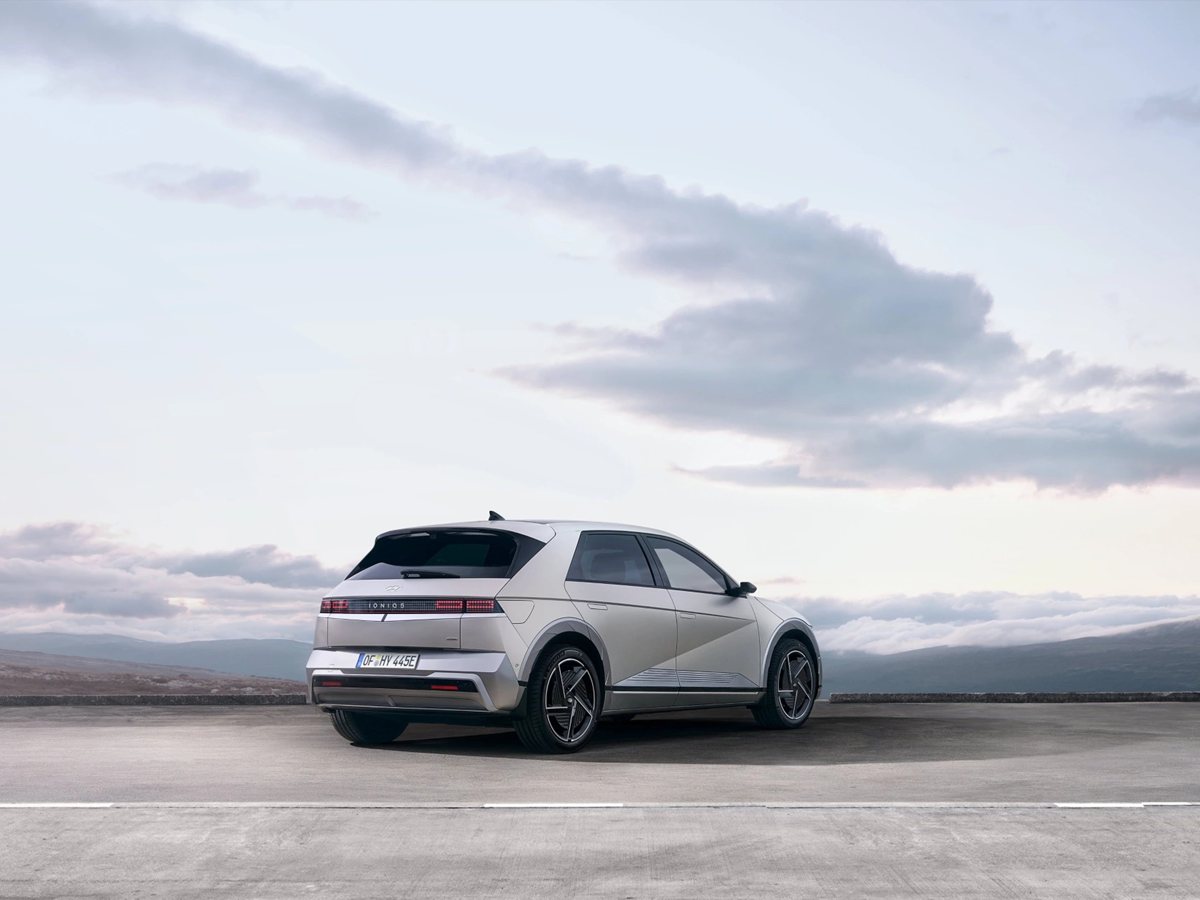 Hyundai IONIQ 5 gris de tres cuartos trasero en una explanada con nubes al fondo