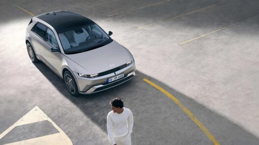 Hyundai IONIQ 5 gris visto desde arriba en un aparcamiento con un hombre vestido de blanco