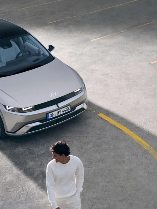 Hyundai IONIQ 5 gris visto desde arriba en un aparcamiento con un hombre vestido de blanco