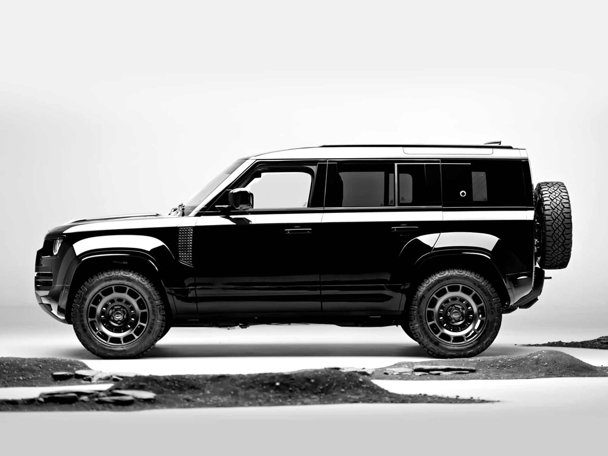 Land Rover Defender negro sobre un camino de grava, imagen oficial de la ficha de landrover.es