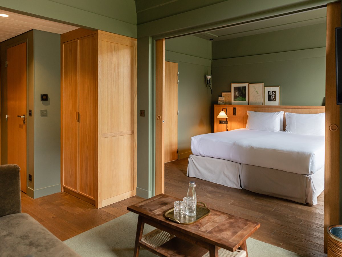 Junior Suite Libellule de Les Sources de Cheverny con paredes verdes, armario de roble, cama doble y salón abierto al dormitorio