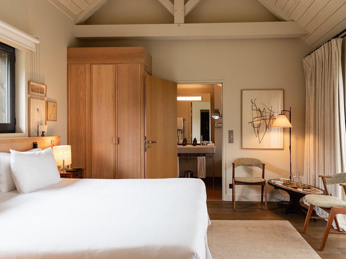 Habitación Prestige La Bergeronnette Grise de Les Sources de Cheverny con vigas vistas, cama blanca y baño separado con lavabo doble al fondo