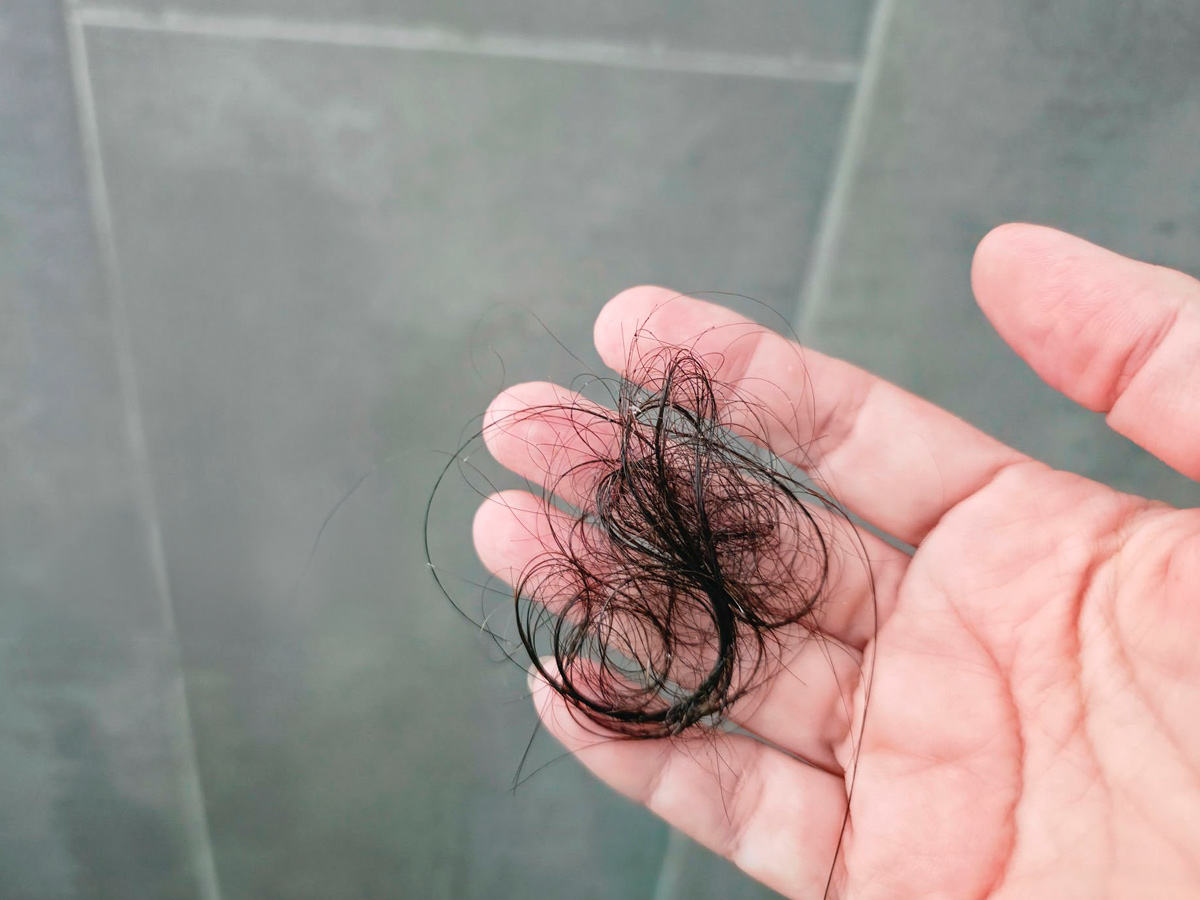 puñado de pelos en la mano de un hombre