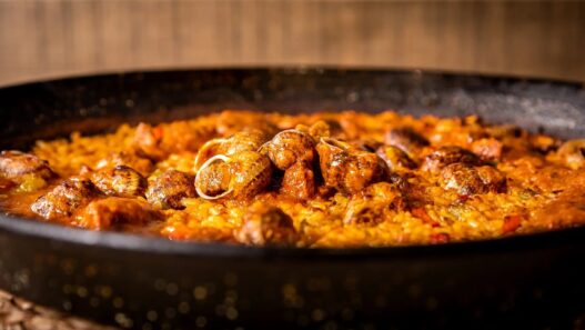 Arroz seco de caracoles serranos con ibéricos en paellera en la arrocería Aynaelda, Latina, Madrid