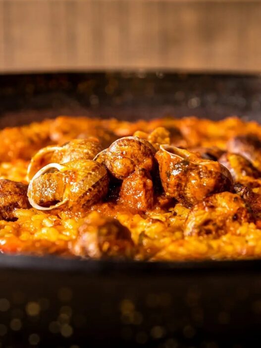 Arroz seco de caracoles serranos con ibéricos en paellera en la arrocería Aynaelda, Latina, Madrid