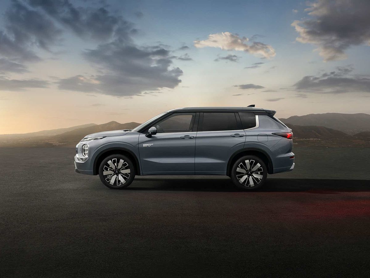 Mitsubishi Outlander PHEV de tres cuartos delantero en una carretera junto al mar