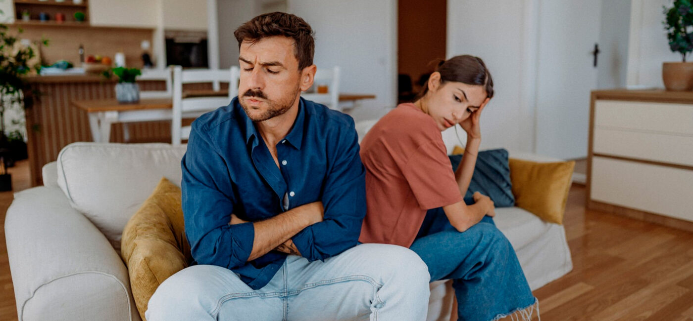pareja joven enfadados en sofá