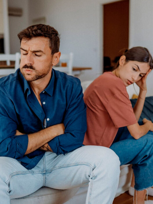 pareja joven enfadados en sofá