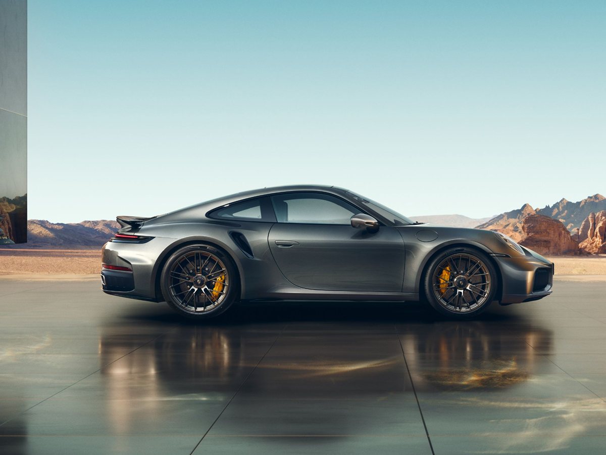 Porsche 911 Turbo S 992.2 de perfil en movimiento por una carretera de montaña