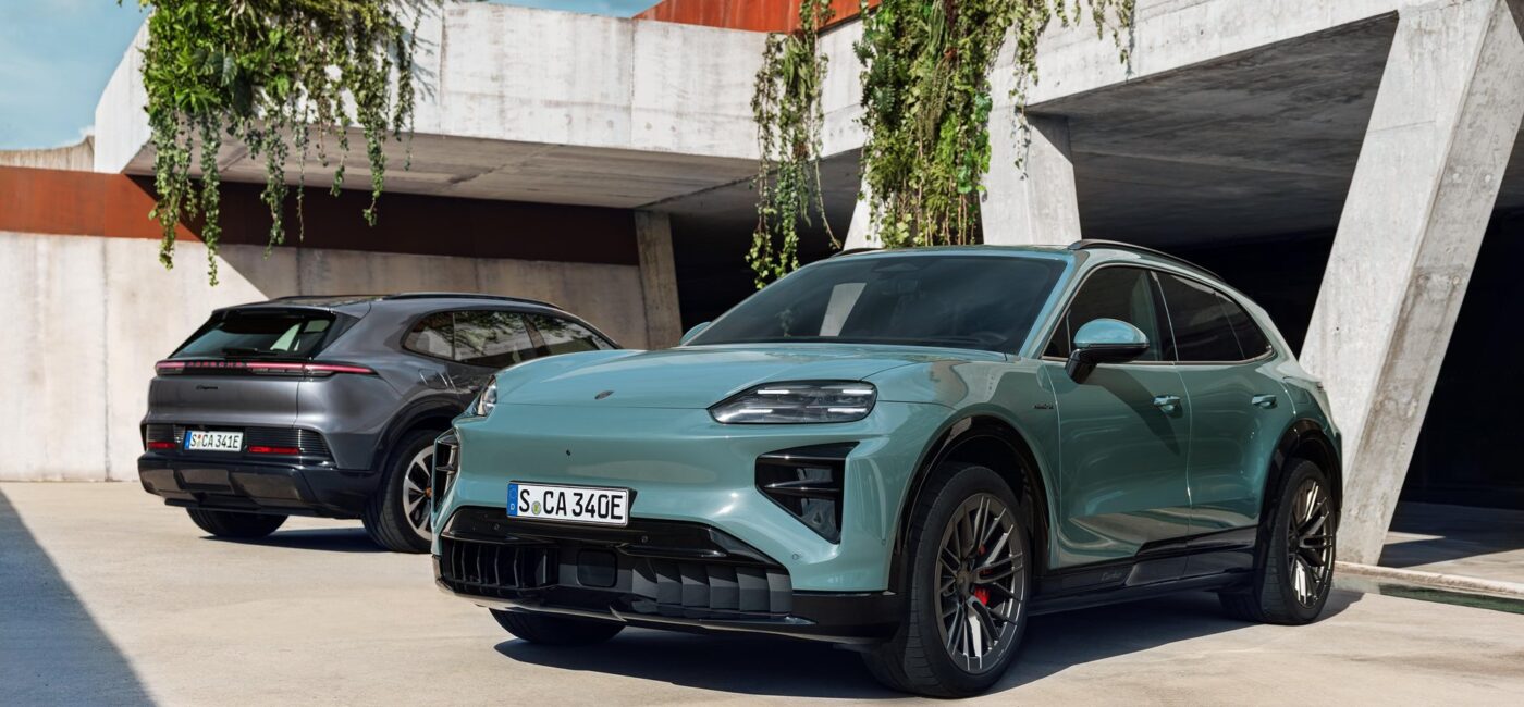 Porsche Cayenne Electric verde de tres cuartos delantero aparcado junto a un muro de hormigón
