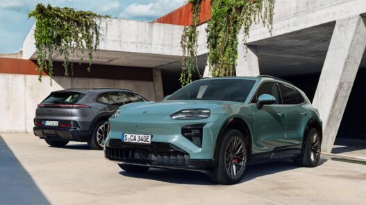 Porsche Cayenne Electric verde de tres cuartos delantero aparcado junto a un muro de hormigón