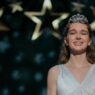Summer H. Howell, como Carrie White, con tiara y vestido claro bajo estrellas doradas en el baile de la serie Carrie de Prime Video