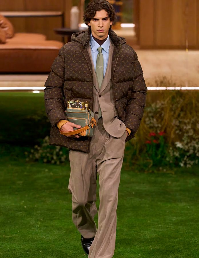 Modelo Hedi Bentekaya en desfile de Louis Vuitton 2026 con Puffer y traje marrón