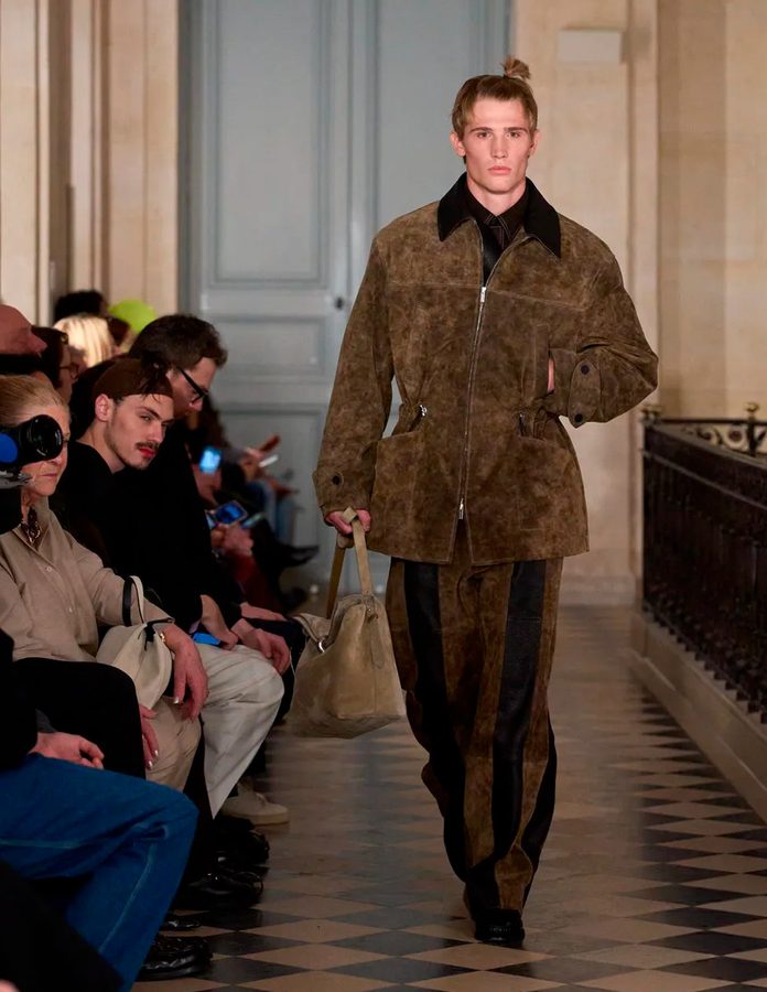 Modelo Jacquemus desfile otoño 2026 con chaqueta de ante piel marrón 