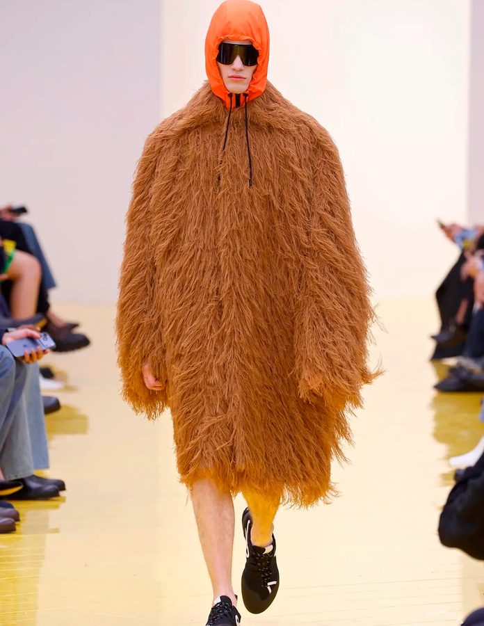 Modelo con abrigo de pelo marron largo y capucha naranja desfile Loewe otoño 2026