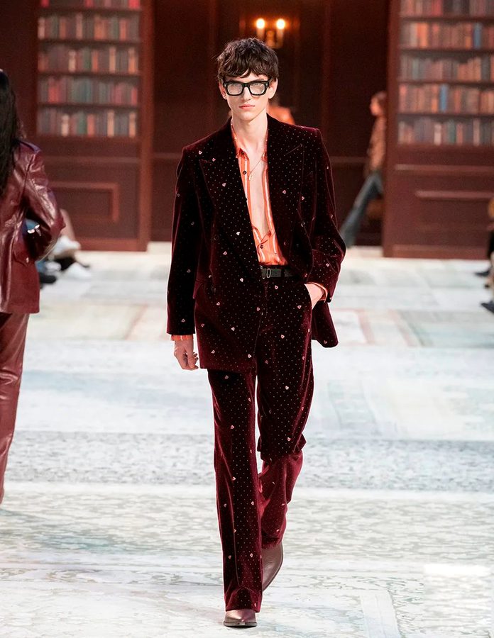 Modelo desfile Amiri otoño 2026 con traje terciopelo burdeos y camisa color salmón