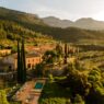 Terra Dominicata, hotel y bodega del Priorat visto desde el aire al atardecer con la sierra del Montsant al fondo y la piscina entre cipreses